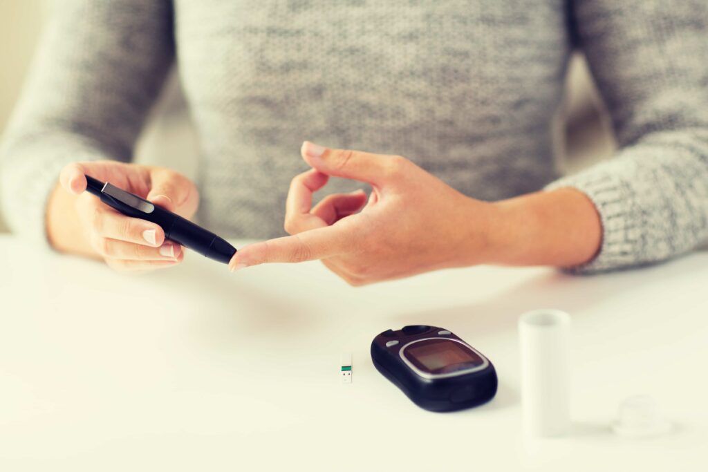 close up of woman making blood test by glucometer